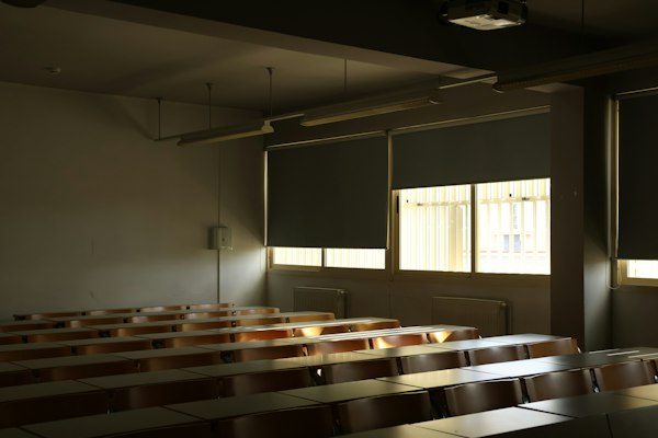 An empty classroom with rows of desks